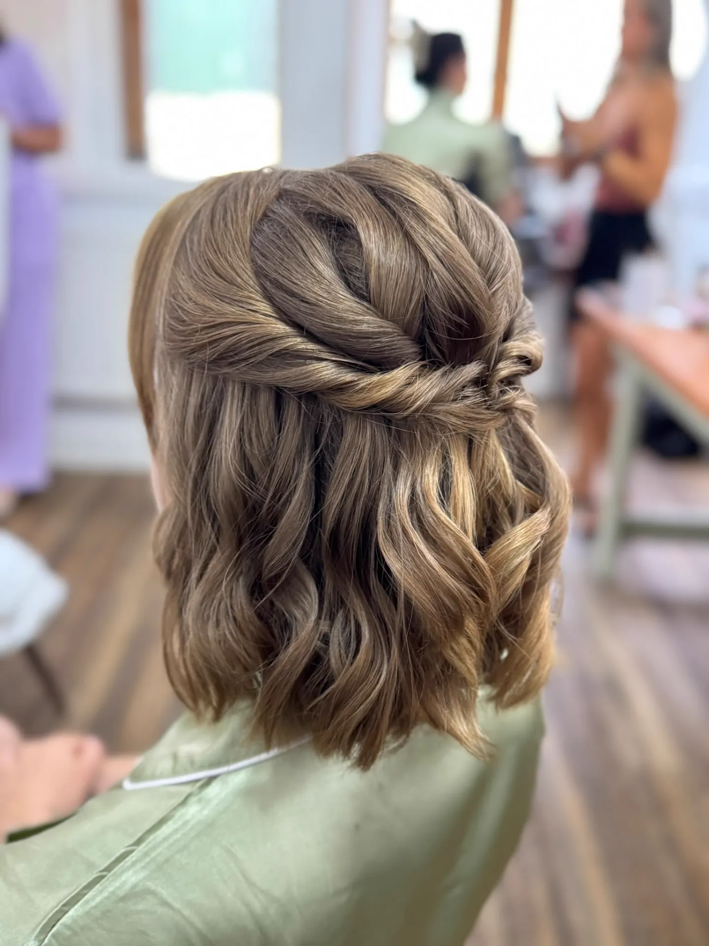 Short half-up bridal style with a twisted detail and soft waves by Be Bridal