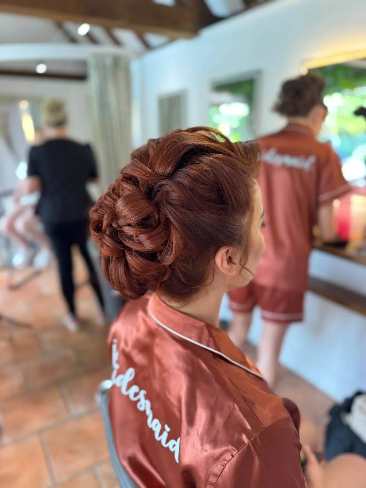 Bridesmaid's sculpted auburn updo on the wedding morning by Be Bridal