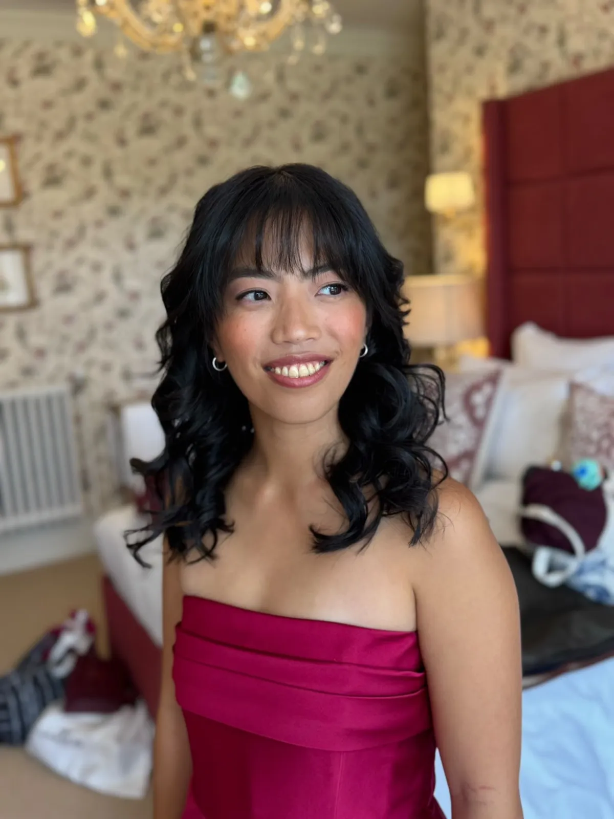 Guest with soft voluminous waves, fringe and glowing makeup by Be Bridal