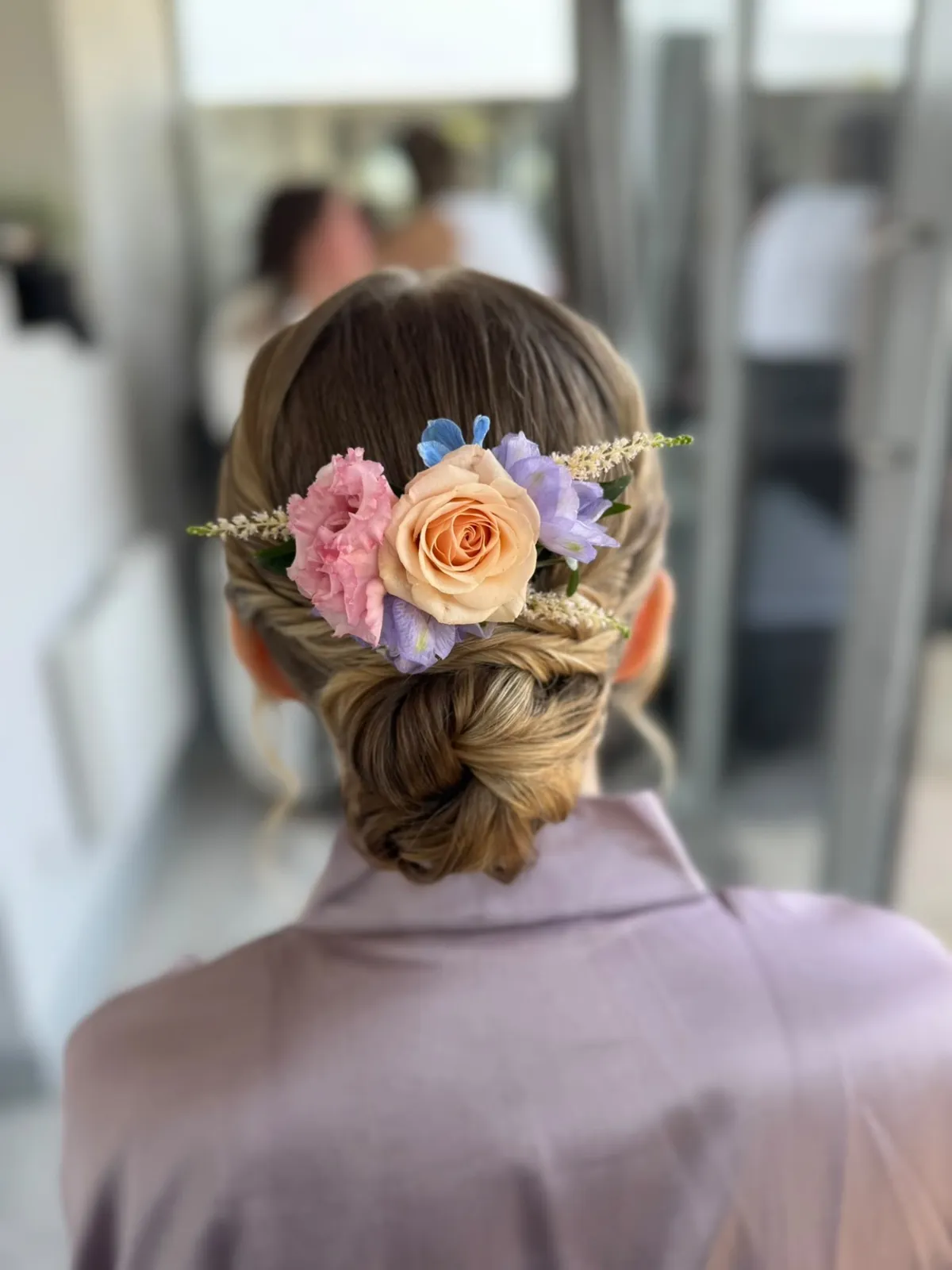 Twisted low bridal bun with a pastel fresh flower crown by Be Bridal