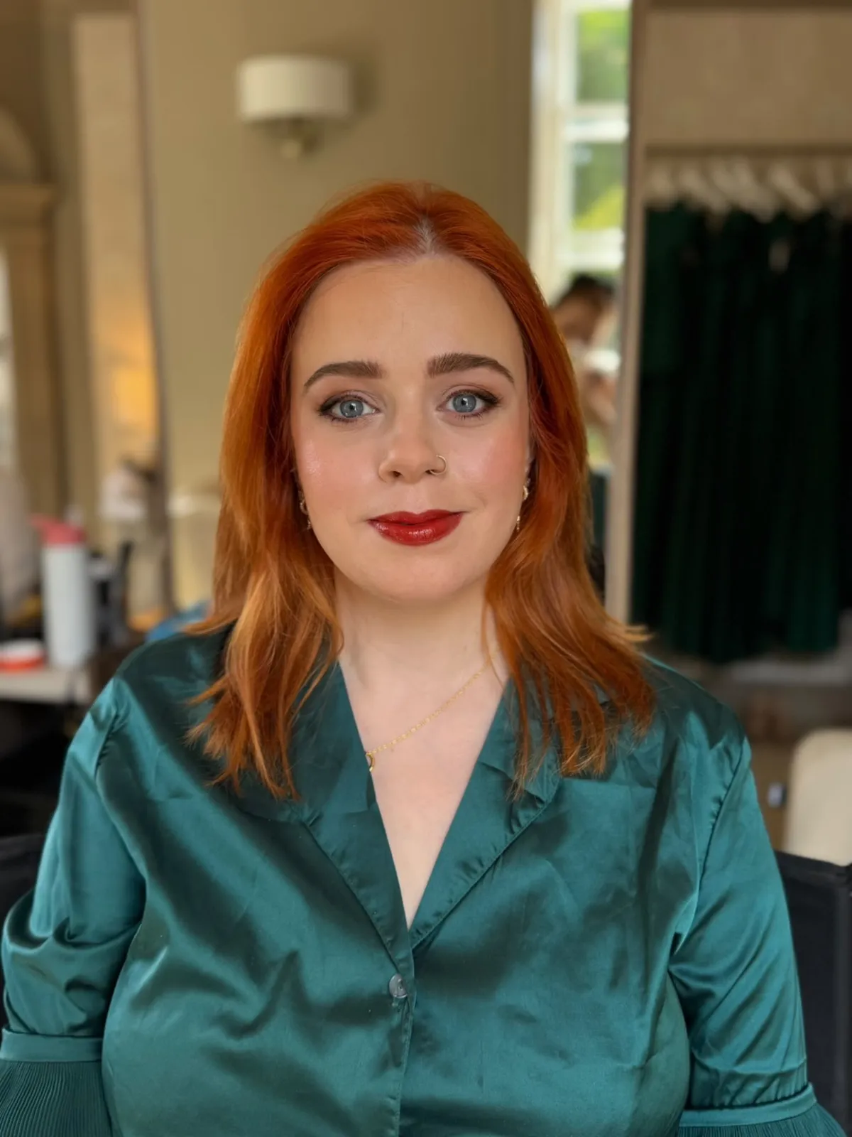 Red-haired client with classic red lip makeup and soft waves by Be Bridal