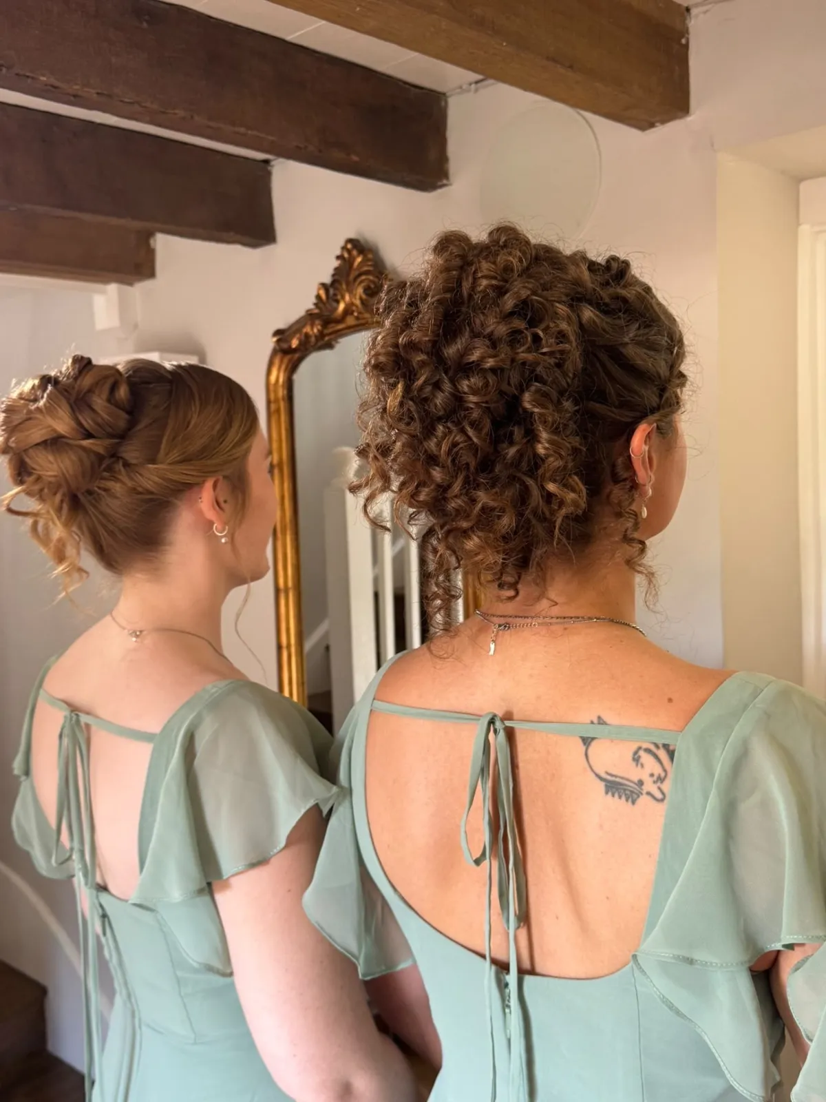 Bridesmaids in sage dresses with curly and twisted updos by Be Bridal