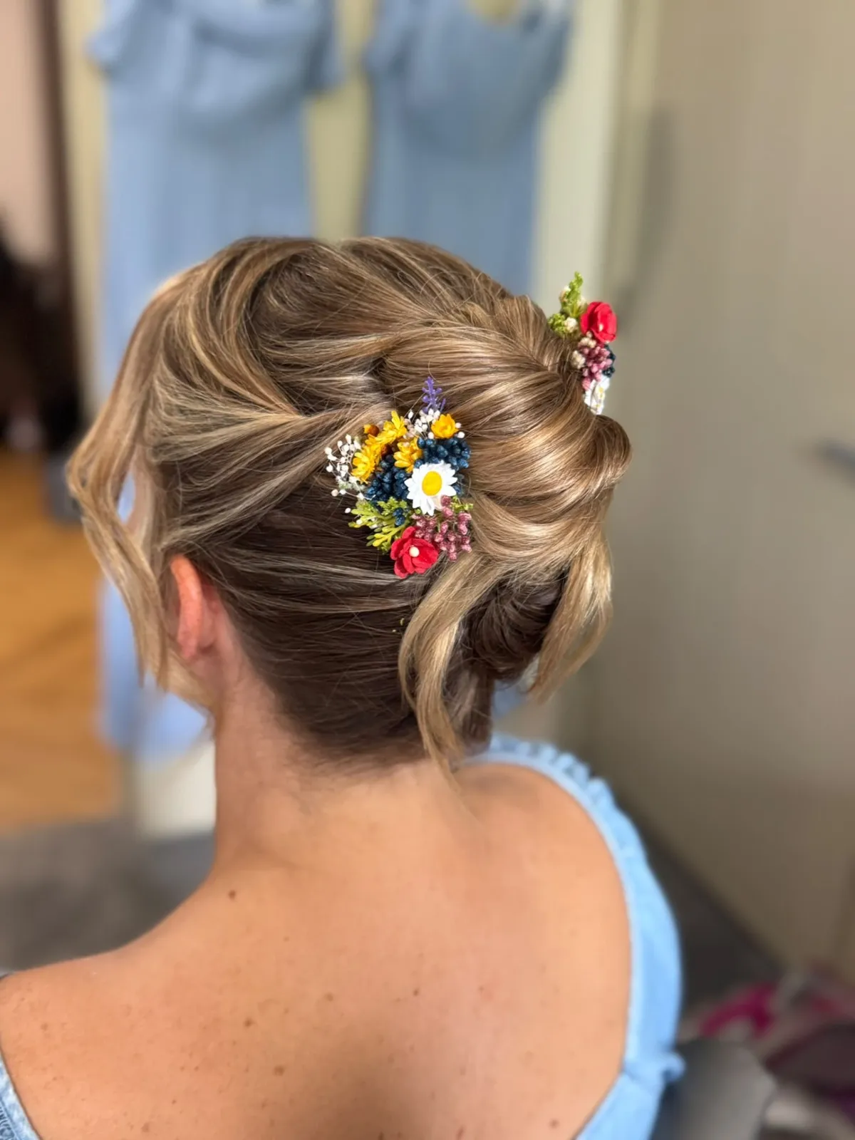 Textured blonde updo with bright wildflower hair pins by Be Bridal