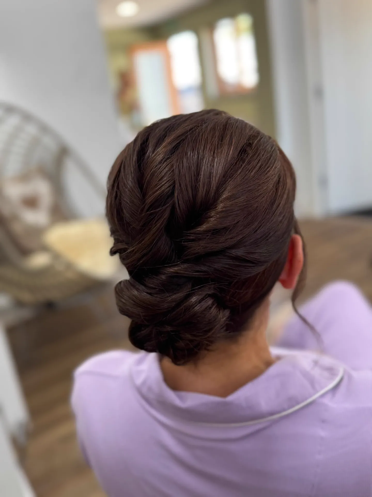 Glossy twisted low chignon with a looped bun by Be Bridal