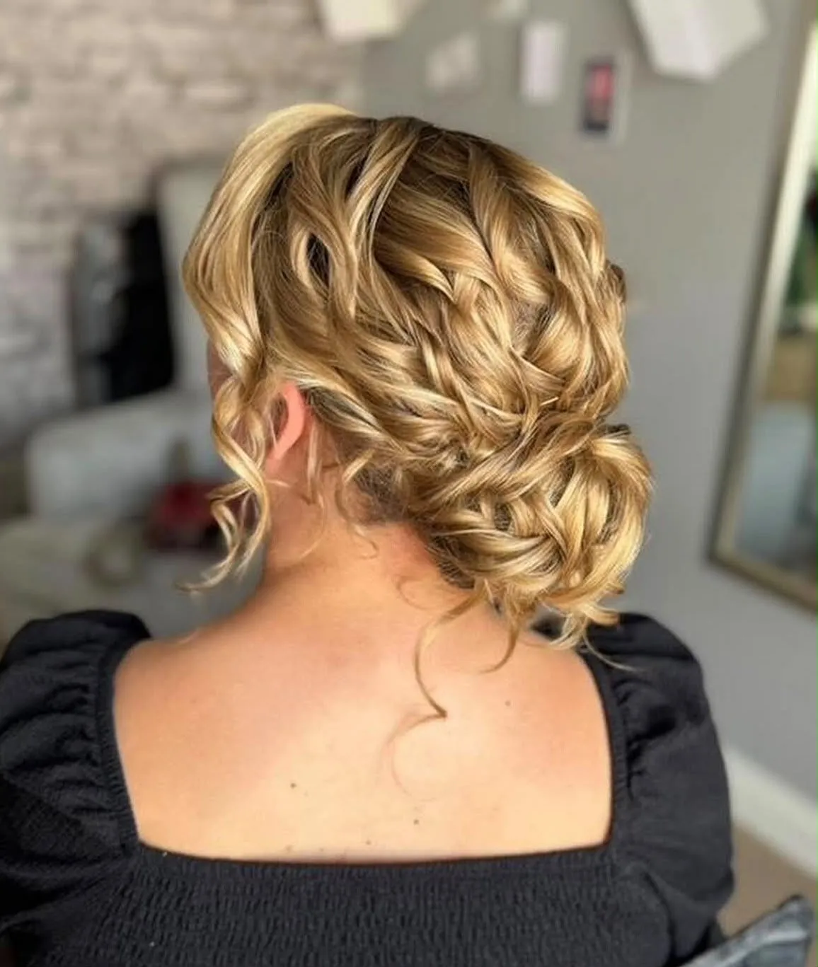 Soft textured blonde side chignon with loose curls by Be Bridal