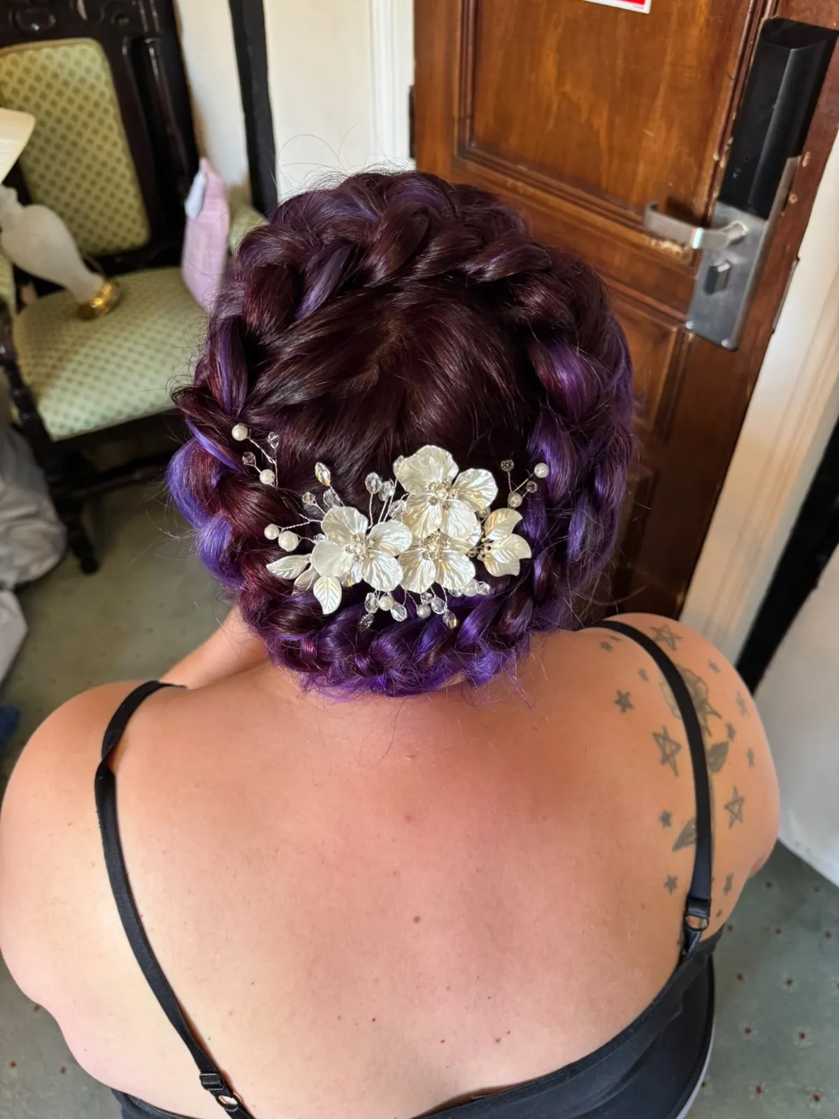 Plum and violet braided crown updo with a pearl floral comb by Be Bridal