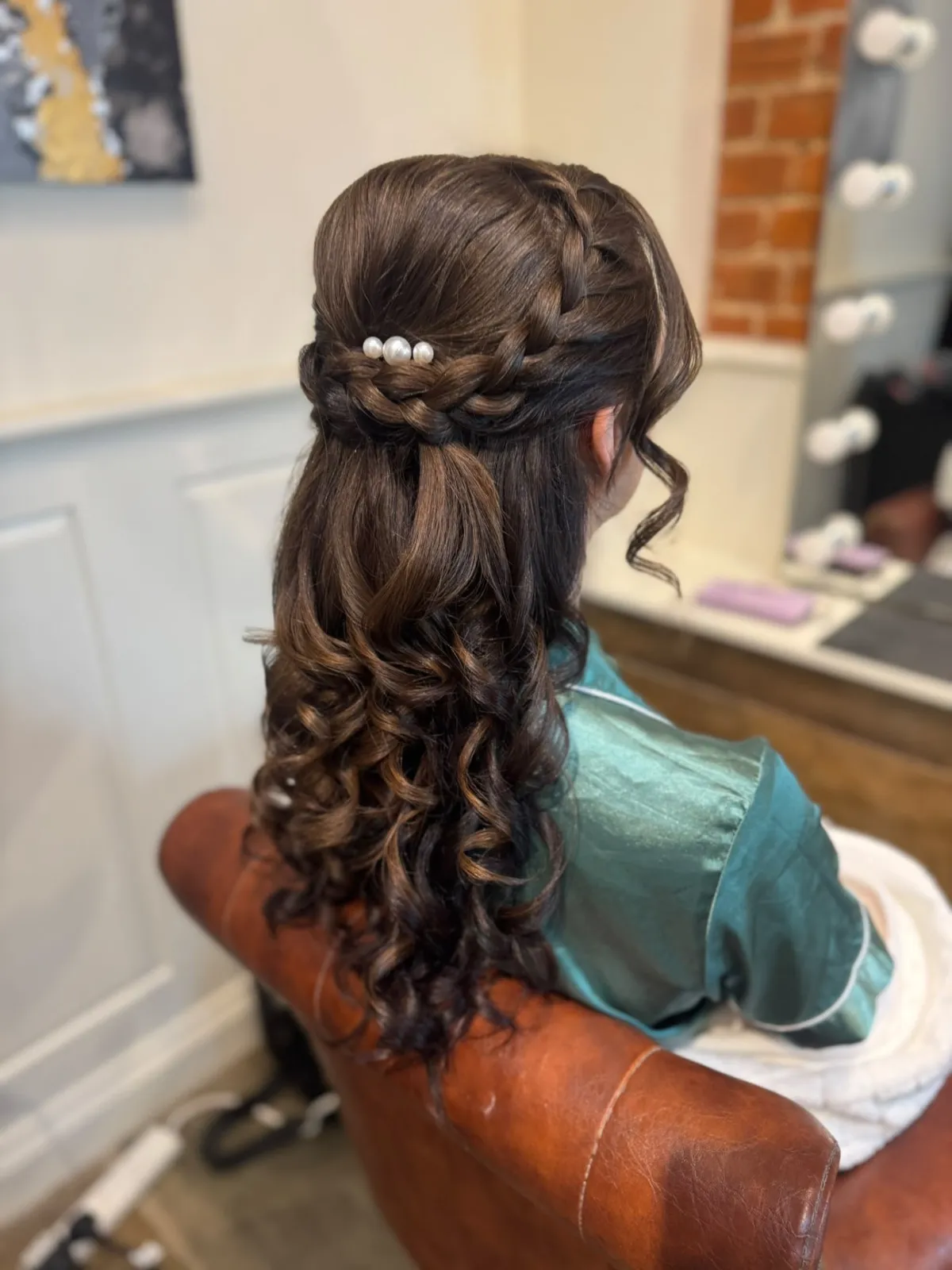 Braided half-up bridal style with a pearl cluster pin by Be Bridal